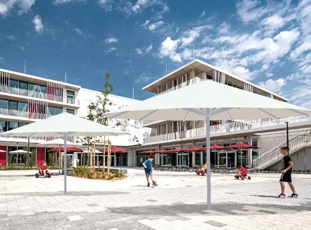 Zwei große weiße Schirme auf einem Schulhof mit spielenden Kindern vor dem Schulgebäude