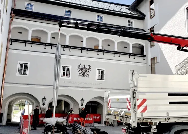 Aufbau eines Trichterschirms mit Ladekran vor einem historischen Gebäude