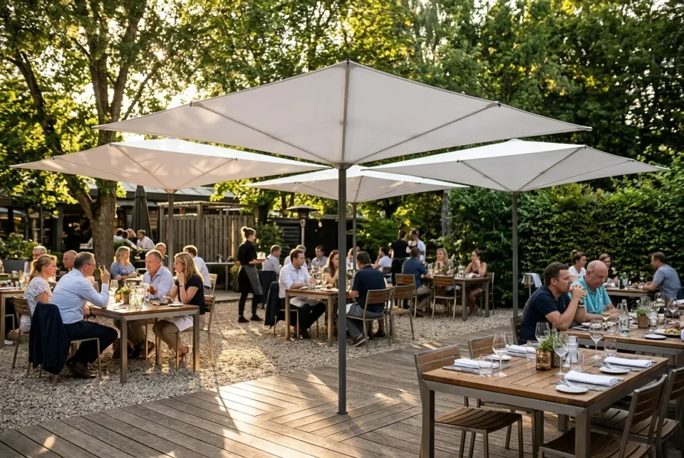 Weiße Prisma Schirme über gedeckten Tischen in einem Gartenrestaurant