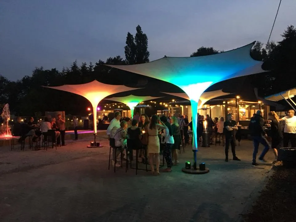 Gelb und türkis beleuchtete Schirme am Abend