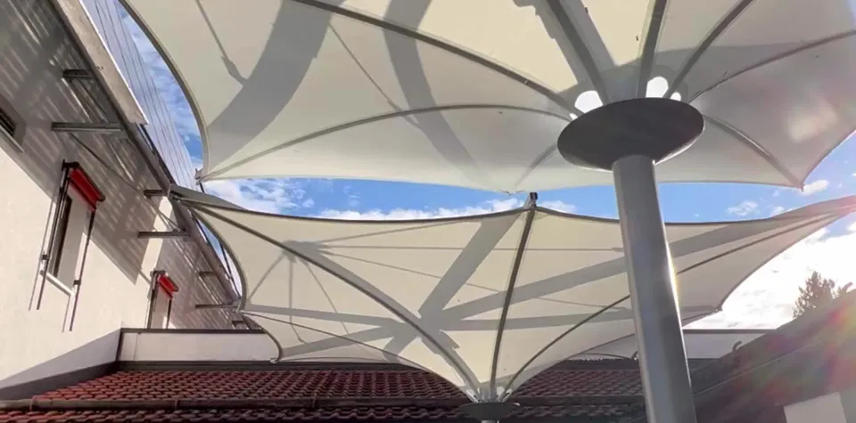 Fest verspannte Trichterschirme an der Traufe eines Gebäudes, Blick nach oben zum Mast