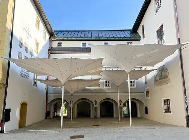 Mehrere verfahrbare Trichterschirme 7 × 7 m über einem Innenhof, Kitzbühel