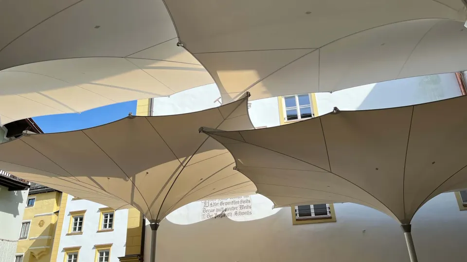Verfahrbare Trichterschirme 7 × 7 m von unten vor Altstadthäusern, Kitzbühel