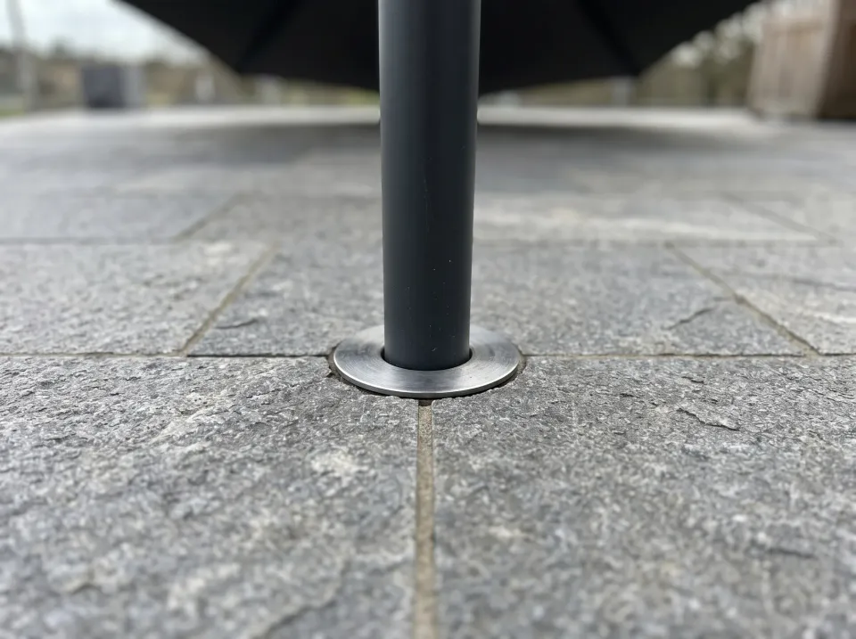 Mast in einer bündig im Natursteinpflaster eingelassenen Bodenhülse